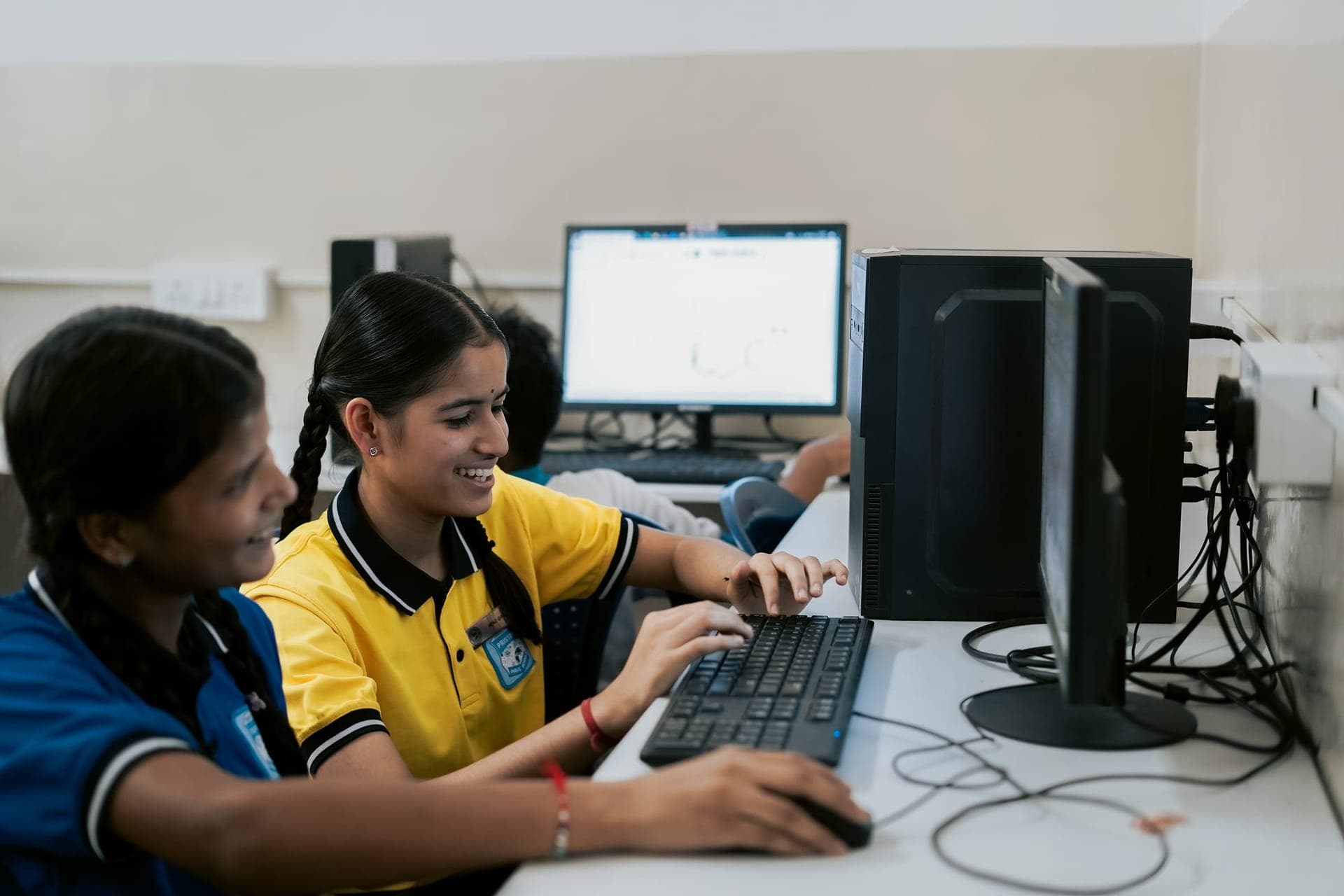 Students working together at a desktop computer in the computer lab
