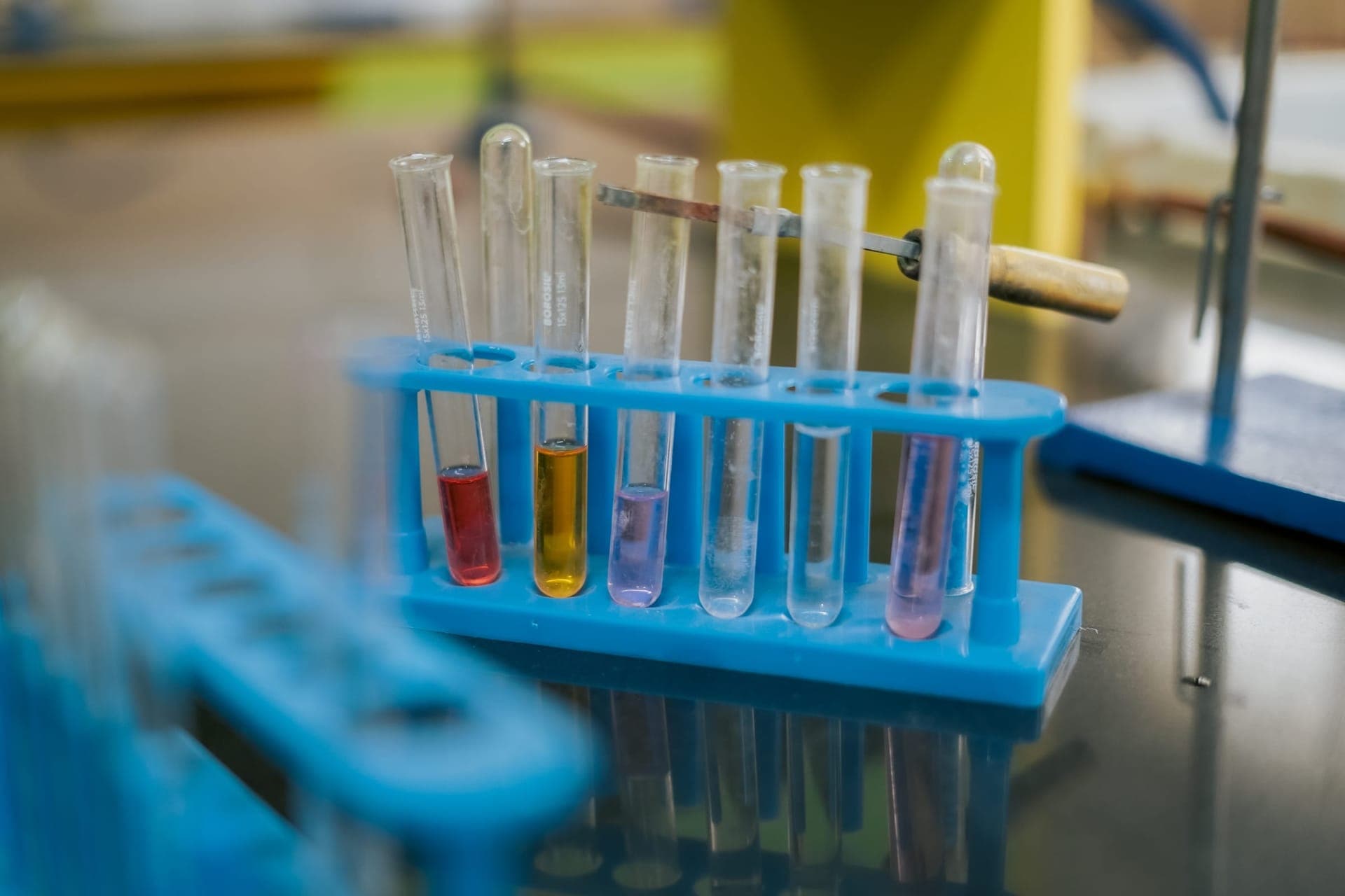 Test tubes with coloured solutions in a rack on a science-lab bench